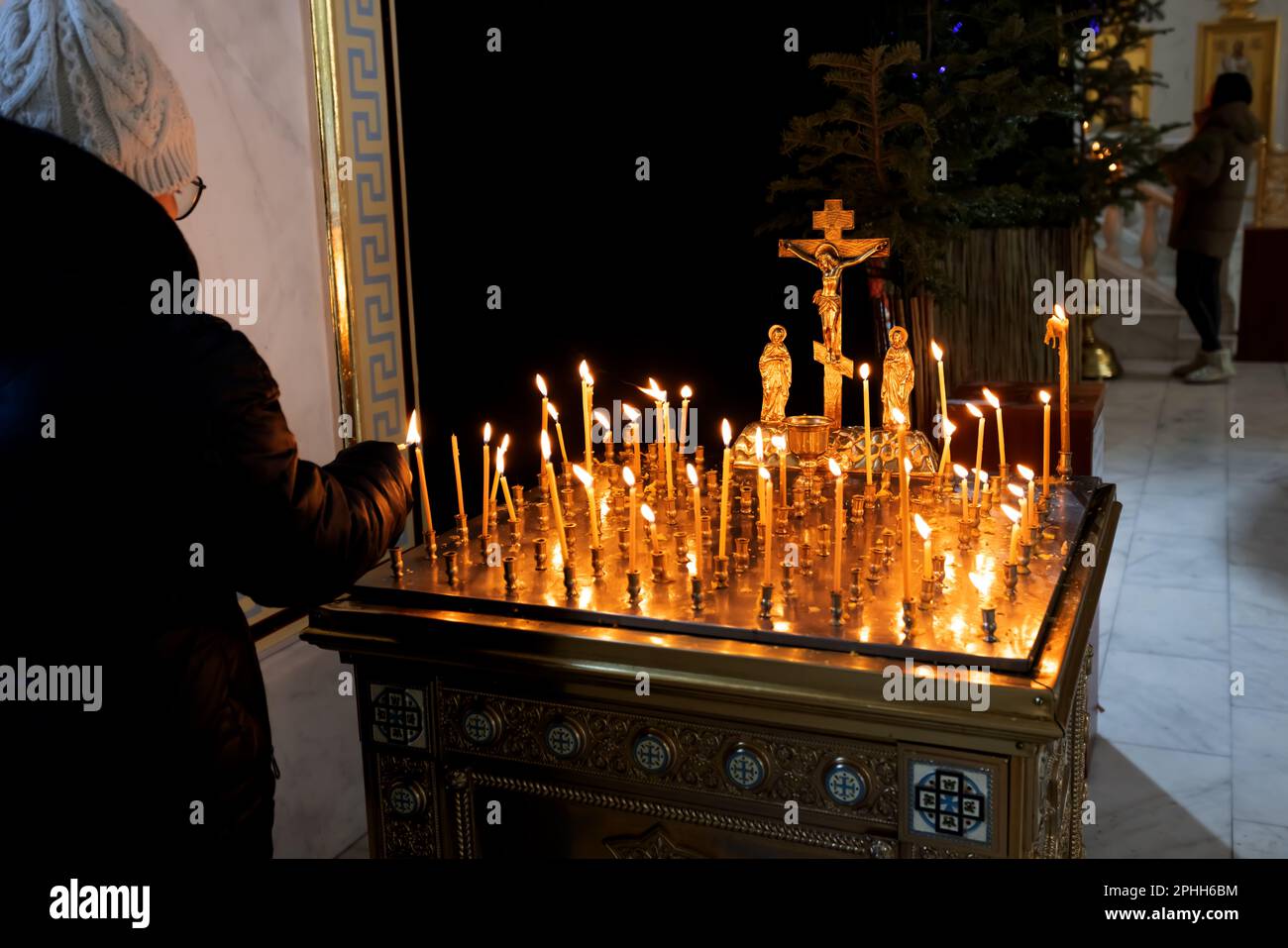 Panakhida, Pasqua, liturgia funeraria nella Chiesa Ortodossa. I cristiani illuminano le candele davanti ad una croce ortodossa con un crocifisso e una brea sacrificale Foto Stock