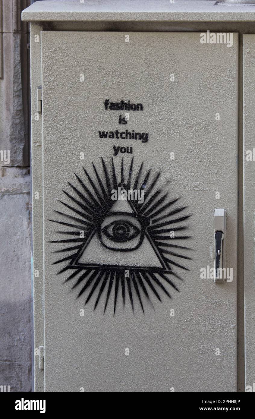 Graffiti su un gabinetto a Barcellona, in Spagna. Interpretazione orwelliana di "Fashion is Watching You". Il grande fratello o il massonico "All Seeing Eye". Foto Stock