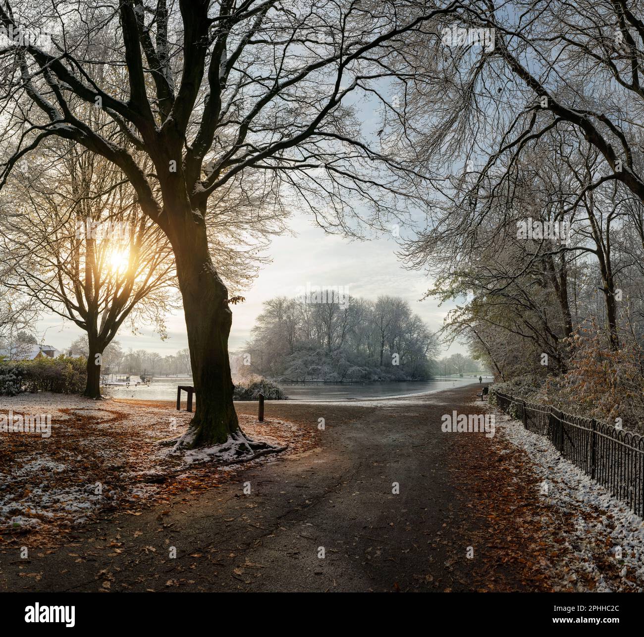 L'isola sul lago in barca nel Platt Fields Park nel sud di Manchester su un inverno gelido mattina con un po 'di luce del sole dietro gli alberi Foto Stock