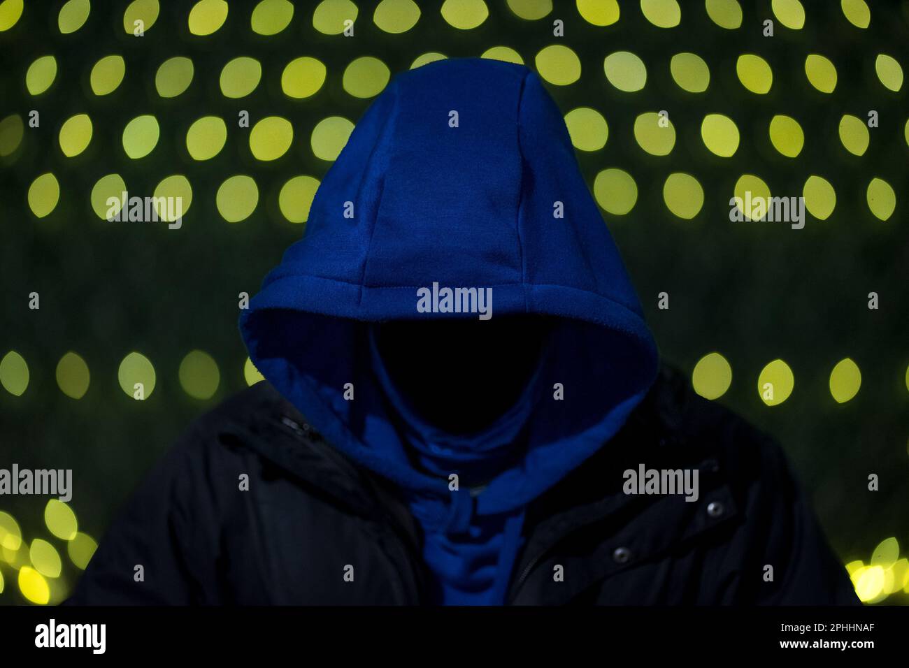 Uomo anonimo senza volto che indossa una felpa con cappuccio mentre si guarda verso il basso, volto non visibile; carta da parati Hacker Foto Stock