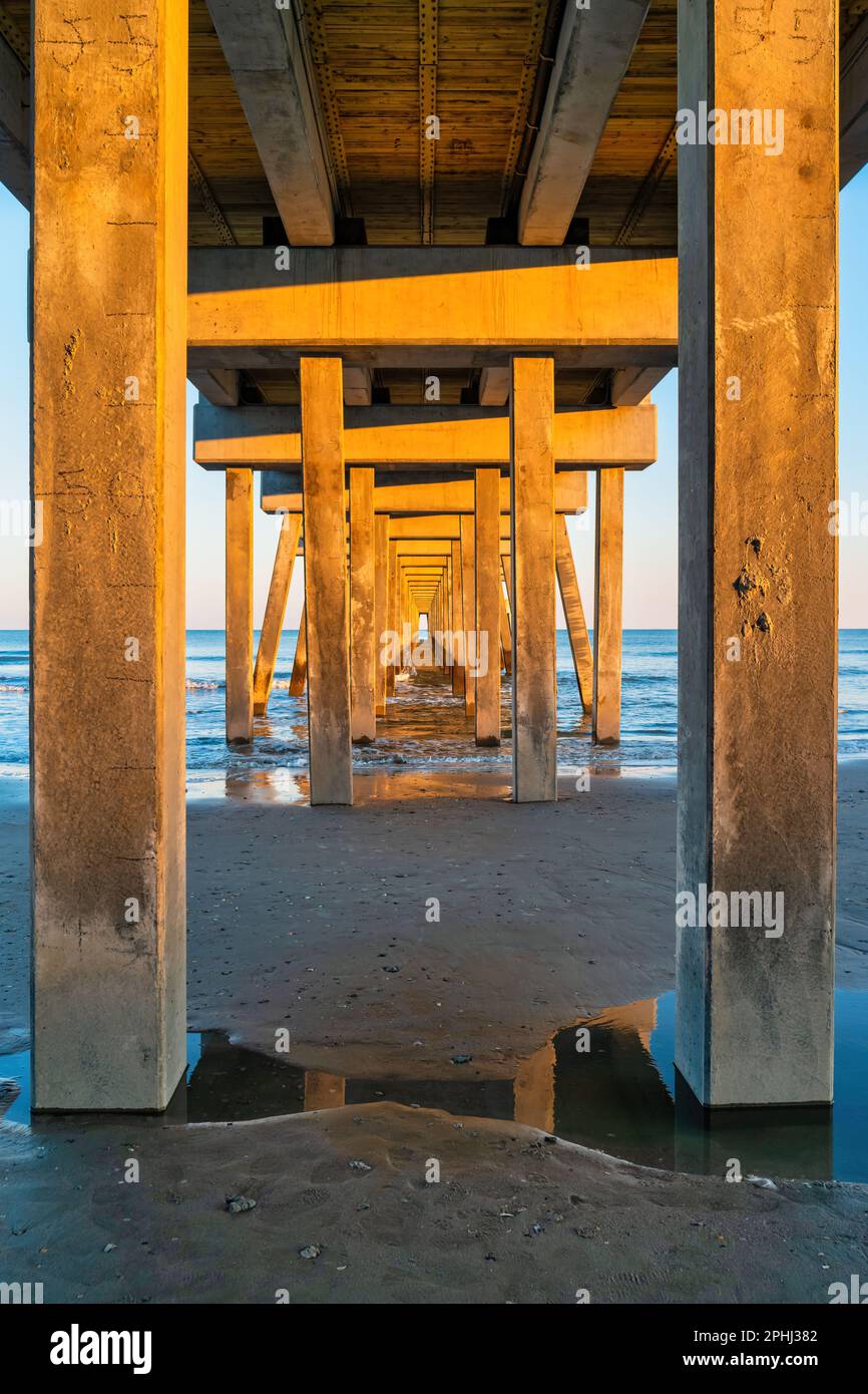 Pilastri del molo di Folly Beach, South Carolina, USA al tramonto. Foto Stock