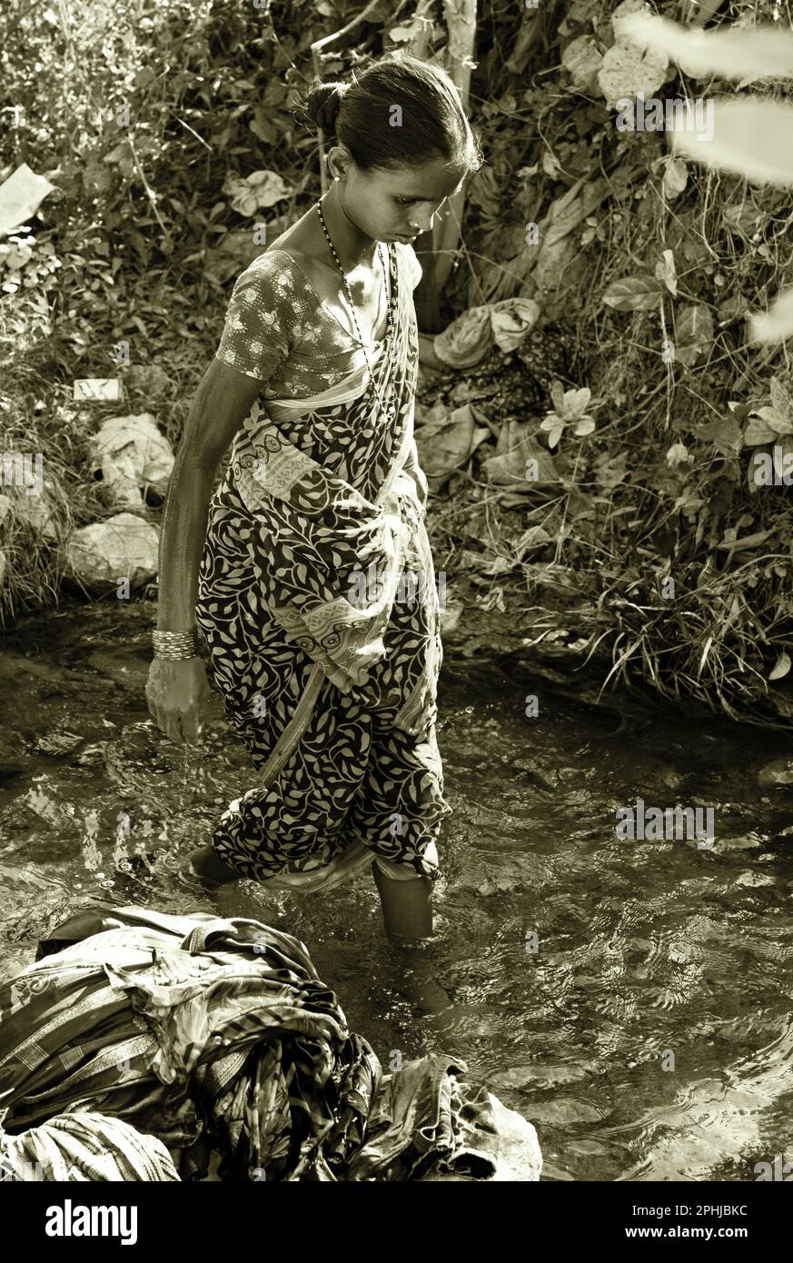 Donna che lava vestiti in fiume in India Foto Stock