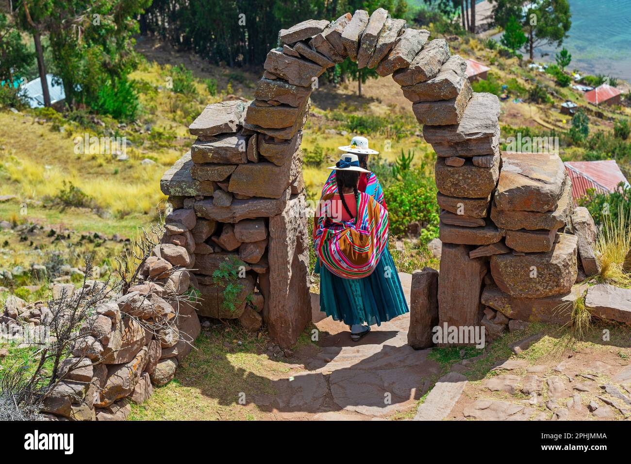 Donne indigene peruviane Quechua in abiti tradizionali a piedi su Isla Taquile, Lago Titicaca, Perù. Foto Stock