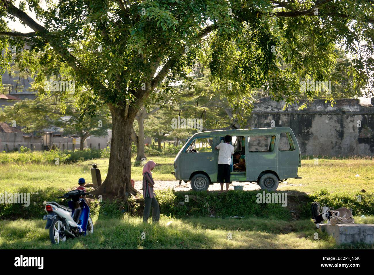 Una moto e un minibus sono parcheggiati dai visitatori vicino a Fort Speelwijk, uno dei beni culturali nella zona ora chiamato Banten lama (Old Banten) a Serang, Banten, Indonesia, in questa foto scattata nel 2010. "La sostenibilità del patrimonio culturale è fortemente legata all'effettiva partecipazione delle comunità locali alla conservazione e alla gestione di queste risorse", secondo un team di scienziati guidati da Sunday Oladipo Oladeji nel loro articolo di ricerca pubblicato su Sage Journals il 28 ottobre 2022. L'area di Banten lama (Old Banten) faceva parte dell'importante porto di Banten Sultanato, Foto Stock