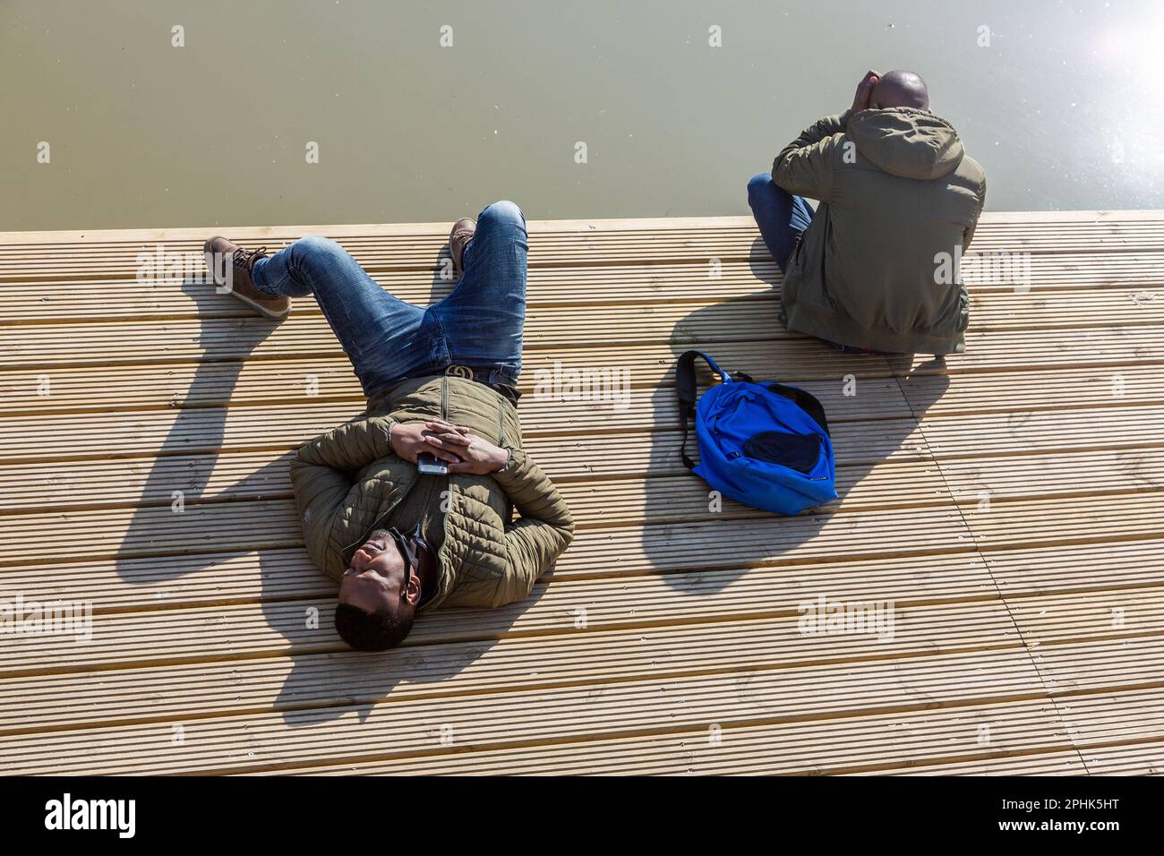 Due giovani che prendono il sole sulle rive del canale a Bruxelles. Foto Stock