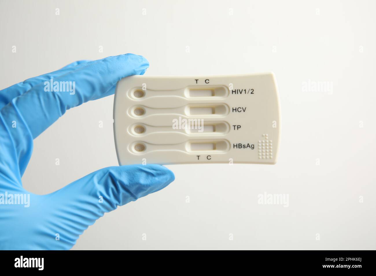 Medico in guanti con test usa e getta express per l'epatite su sfondo bianco, primo piano Foto Stock