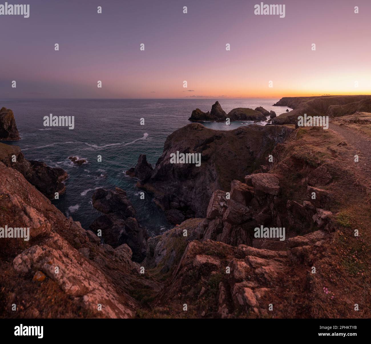 Crepato da una scogliera sul bordo della Penisola di Lizard, guardando giù sulle formazioni rocciose e la geologia di Kynance Cove, una destinazione turistica in Cornovaglia Foto Stock