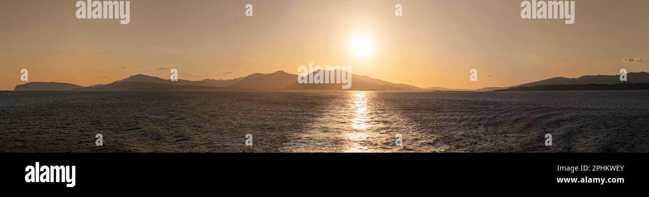 Guardando indietro all'Isola di Mull dal traghetto per Oban al tramonto, nelle Ebridi interne, Scozia, in una giornata estiva che viaggia verso le isole Foto Stock