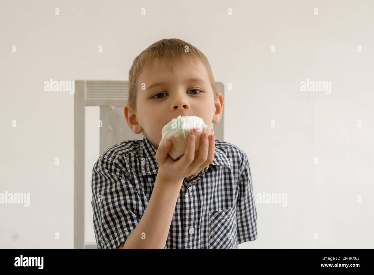 Un ragazzo sta mangiando una torta. La gioia alimentare dei dolci. Foto Stock