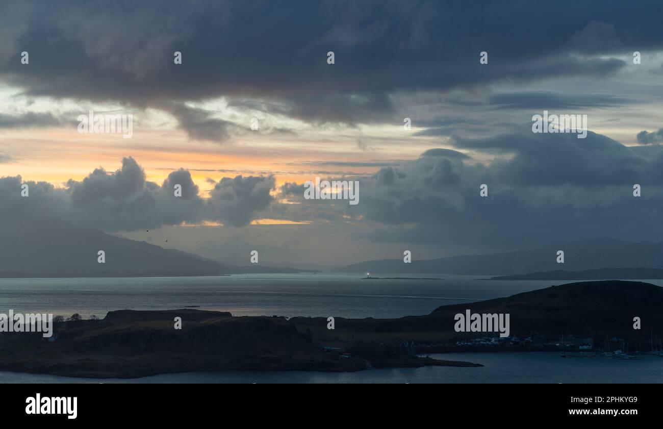 Guardando fuori verso Mull, Lismore Lighthouse e il Firth of Lorne da Pilpit Hill a Oban nelle Ebridi interne in Scozia al crepuscolo dopo il tramonto Foto Stock