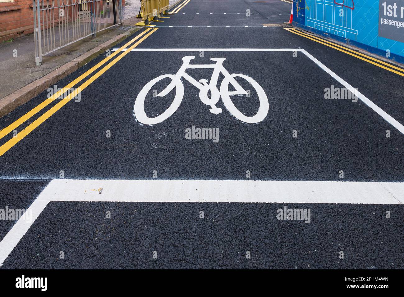 Profilo di una bicicletta dipinta su strada asfaltata che mostra lo spazio per i ciclisti di attendere al semaforo Foto Stock