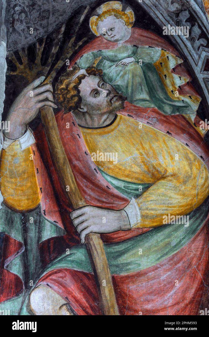San Cristoforo porta un pesante fardello sulle sue spalle - il Cristo bambino che porta i peccati dell'umanità. Affresco tardogotico nel chiostro medievale accanto al Duomo di Bressanone (Cattedrale di Santa Maria Assunta) a Bressanone-Bressanone, alto Adige, Italia. Foto Stock
