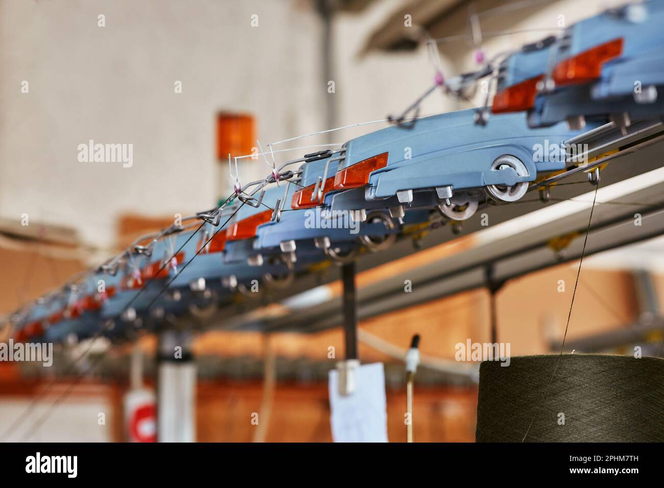 Una fila di elementi di guida di una grande macchina per maglieria industriale, Foto Stock