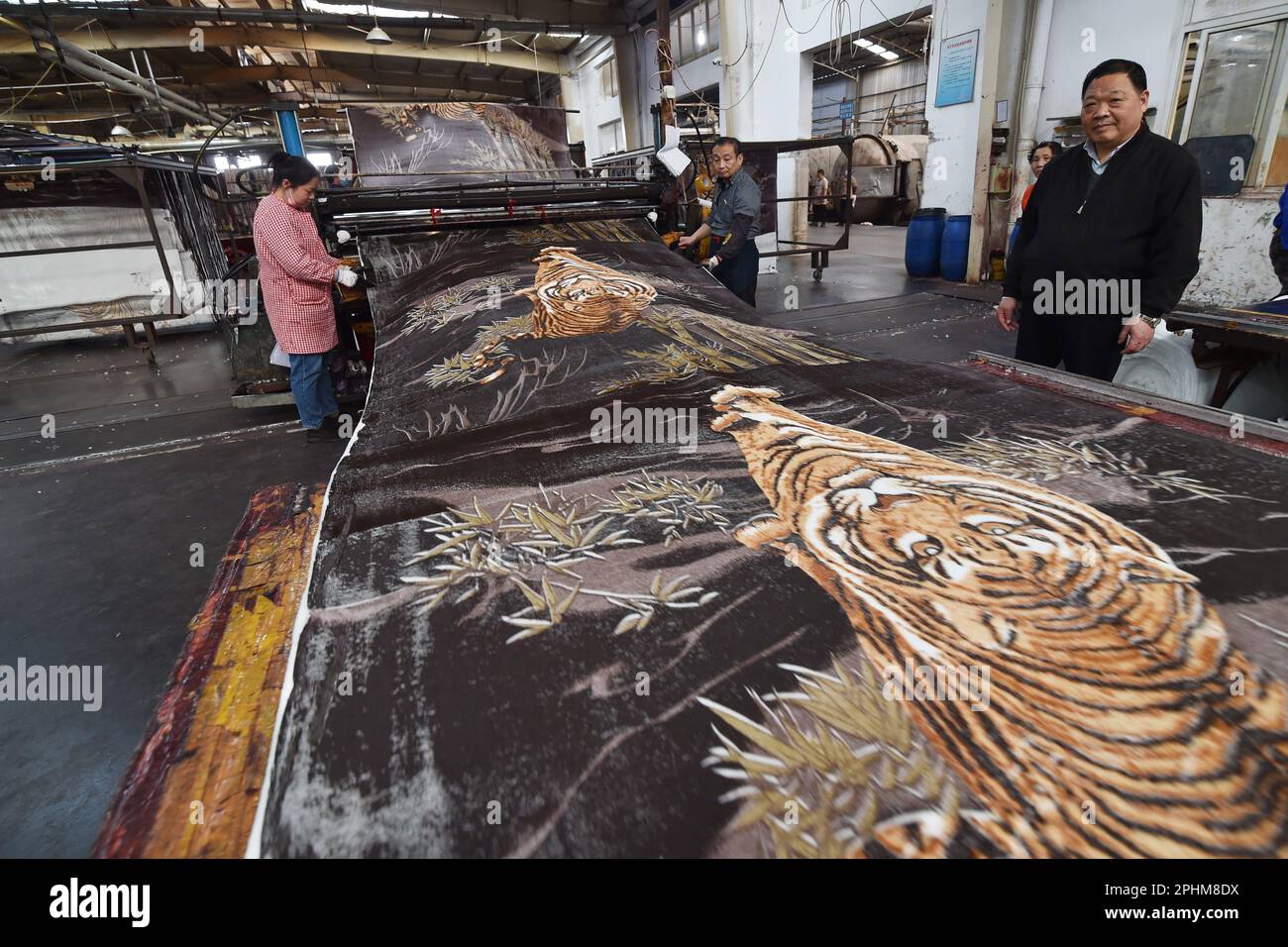 SUQIAN, CINA - 29 MARZO 2023 - gli operai stampano i modelli sulle coperte ad un laboratorio di tintura di una fabbrica tessile che produce le coperte a Suqian, Cina orientale Foto Stock