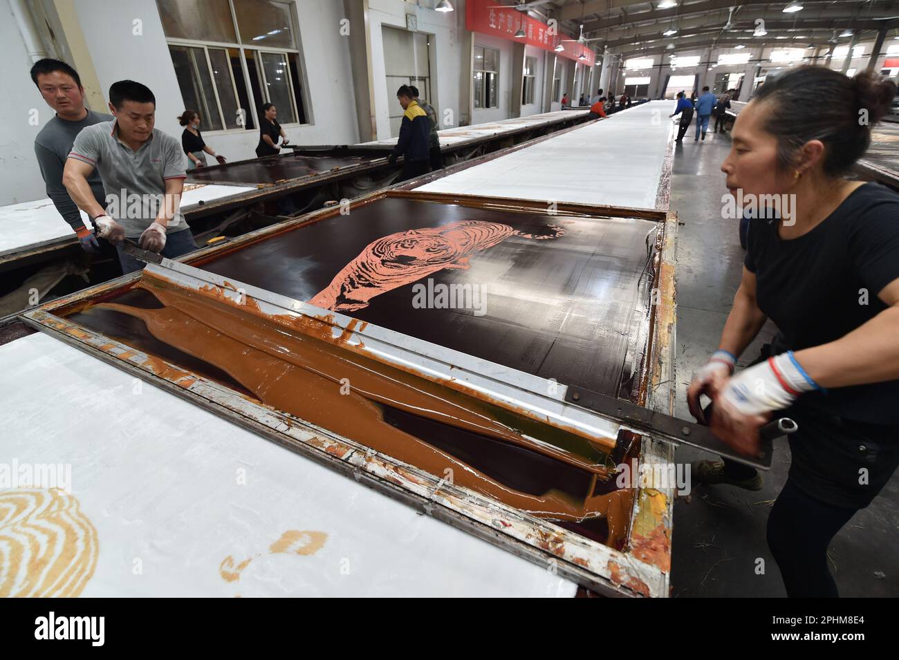 SUQIAN, CINA - 29 MARZO 2023 - gli operai stampano i modelli sulle coperte ad un laboratorio di tintura di una fabbrica tessile che produce le coperte a Suqian, Cina orientale Foto Stock