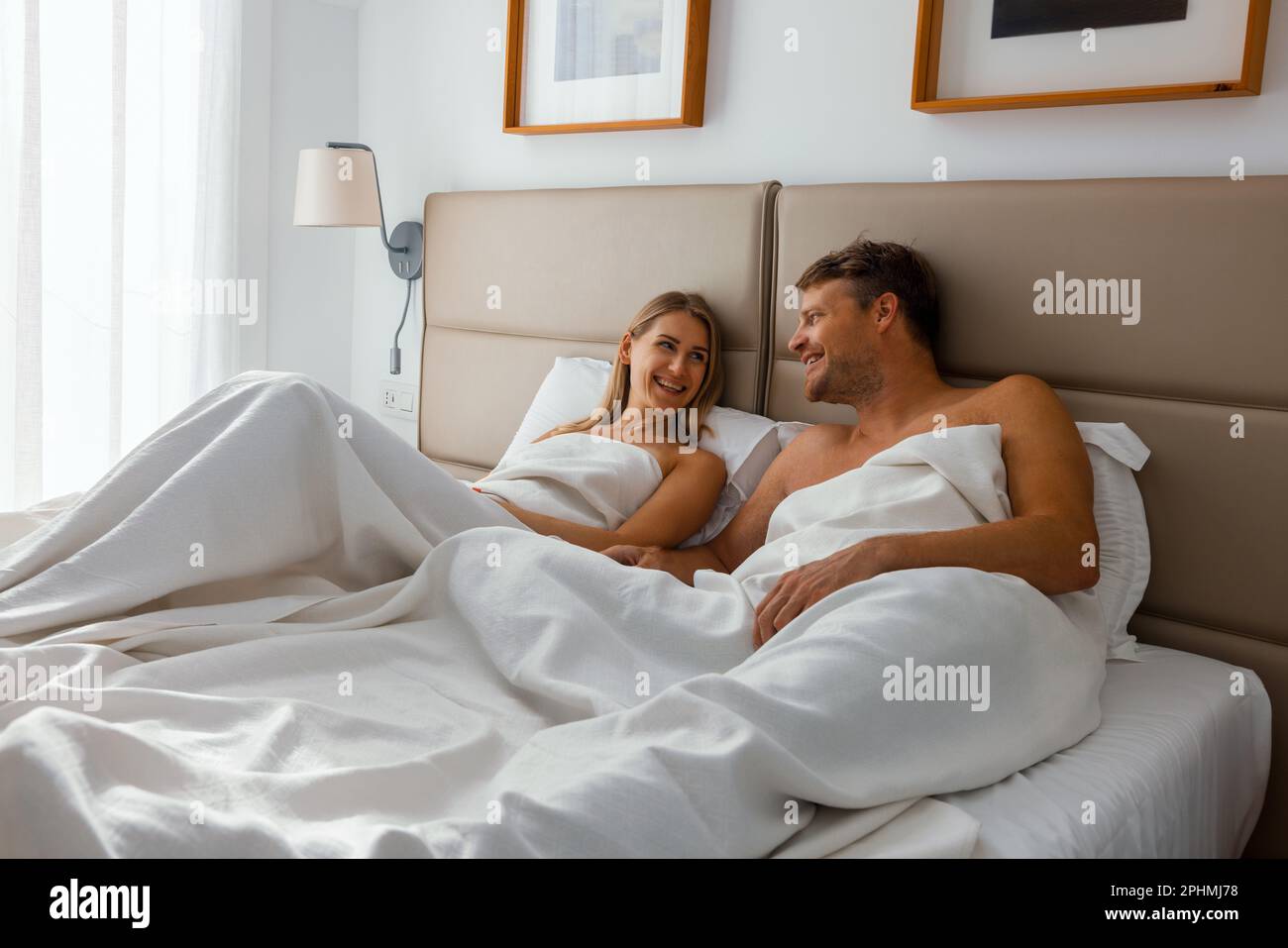 felice coppia è sdraiato in letto da camera e divertirsi insieme al mattino Foto Stock