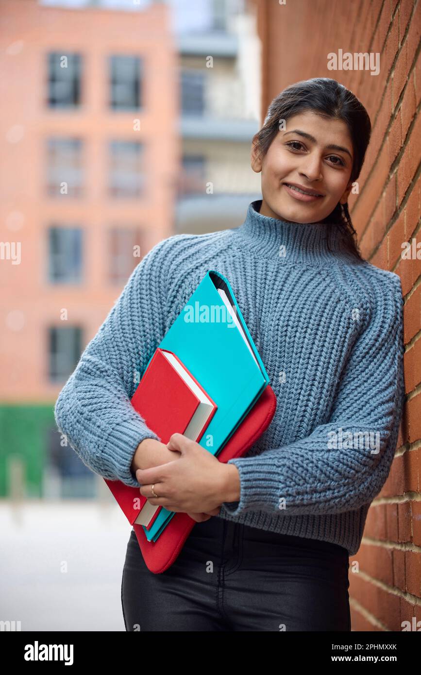 Ritratto di sorridente Female College o studente universitario al di fuori del Campus Building con libri Foto Stock