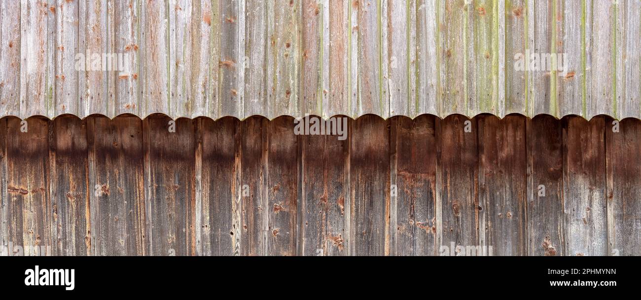 Facciata in legno intemperiato bicolore realizzata con pannelli verticali con archi decorativi Foto Stock Facciata in legno intemperiato bicolore realizzata con pannelli verticali con archi decorativi Foto Stock