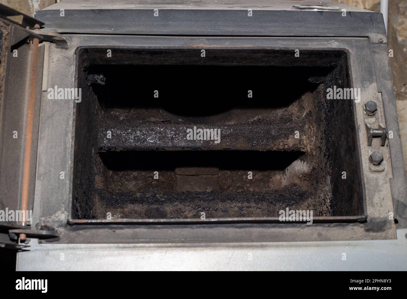 Il forno di una caldaia a combustibile solido in fuliggine. Pulizia e manutenzione della caldaia. Foto Stock