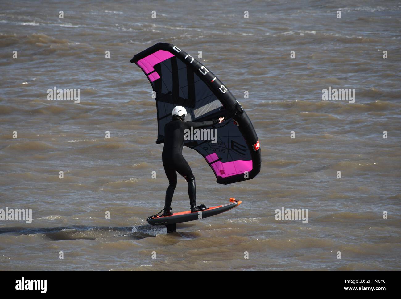 Un surfista alare scivola attraverso un mare mosso alimentato da una brezza rigida al largo della costa Jurrasic nella baia di Lyme. Dorset.UK Foto Stock