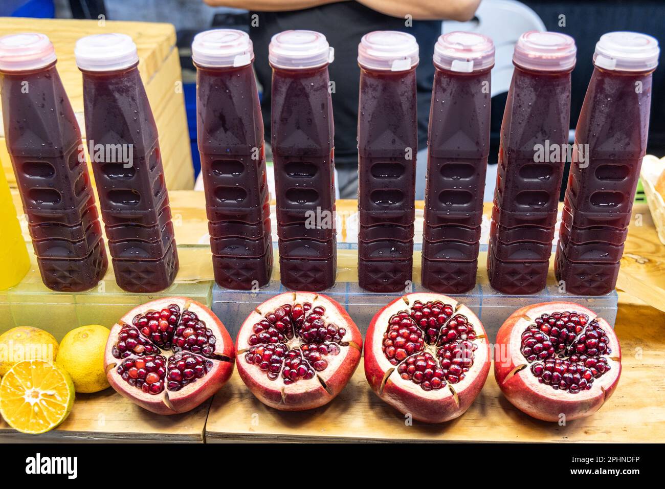La frutta di melograno dimezzata rivelando i relativi arils o semi e il succo in bottiglia è uno del alimento eccellente popolare alto in anti-ossidante Foto Stock