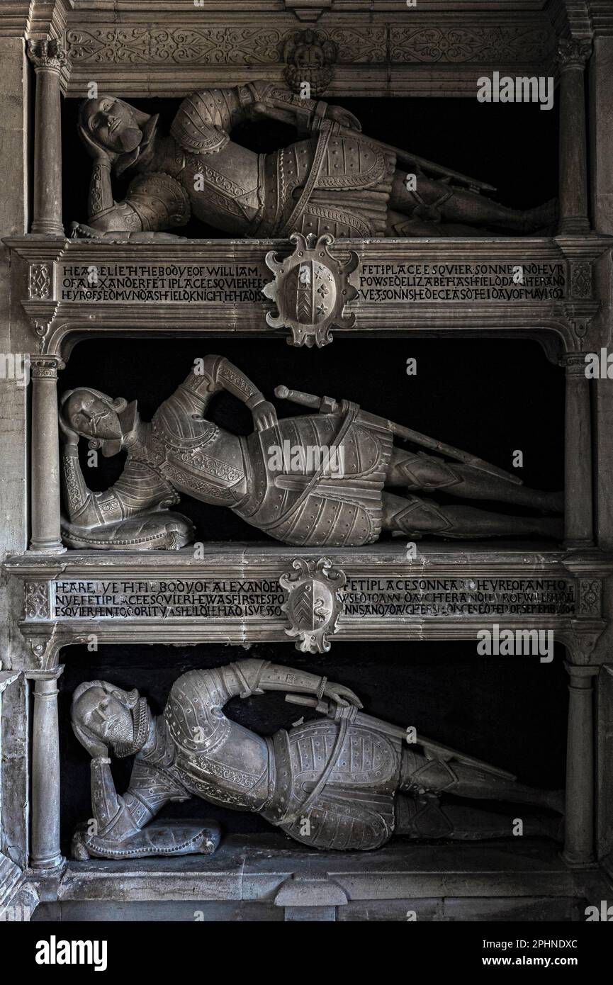 Sullo scaffale: I patriarchi della famiglia Fettiplace degli anni '1500 e dell'inizio degli anni '1600, indossando l'armatura Tudor, giacciono rigidamente sui gomiti in un monumento unico a gradoni nella chiesa parrocchiale di St Mary nel villaggio di Swinbrook, Oxfordshire, Inghilterra, Regno Unito. La casa costruita sul sito della loro residenza apparteneva a Lord e Lady Redesdale, che giacciono nel cimitero con quattro delle loro controverse figlie: Pamela, Nancy, Diana e Unity Mitford. Foto Stock