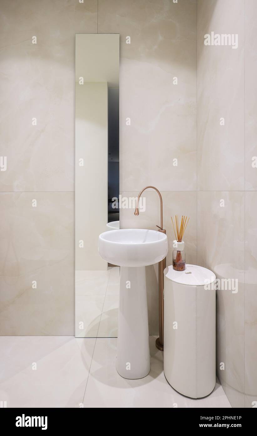 Lavabo in ceramica bianca, rubinetto e specchio all'interno del bagno Foto Stock Lavabo in ceramica bianca, rubinetto e specchio all'interno del bagno Foto Stock