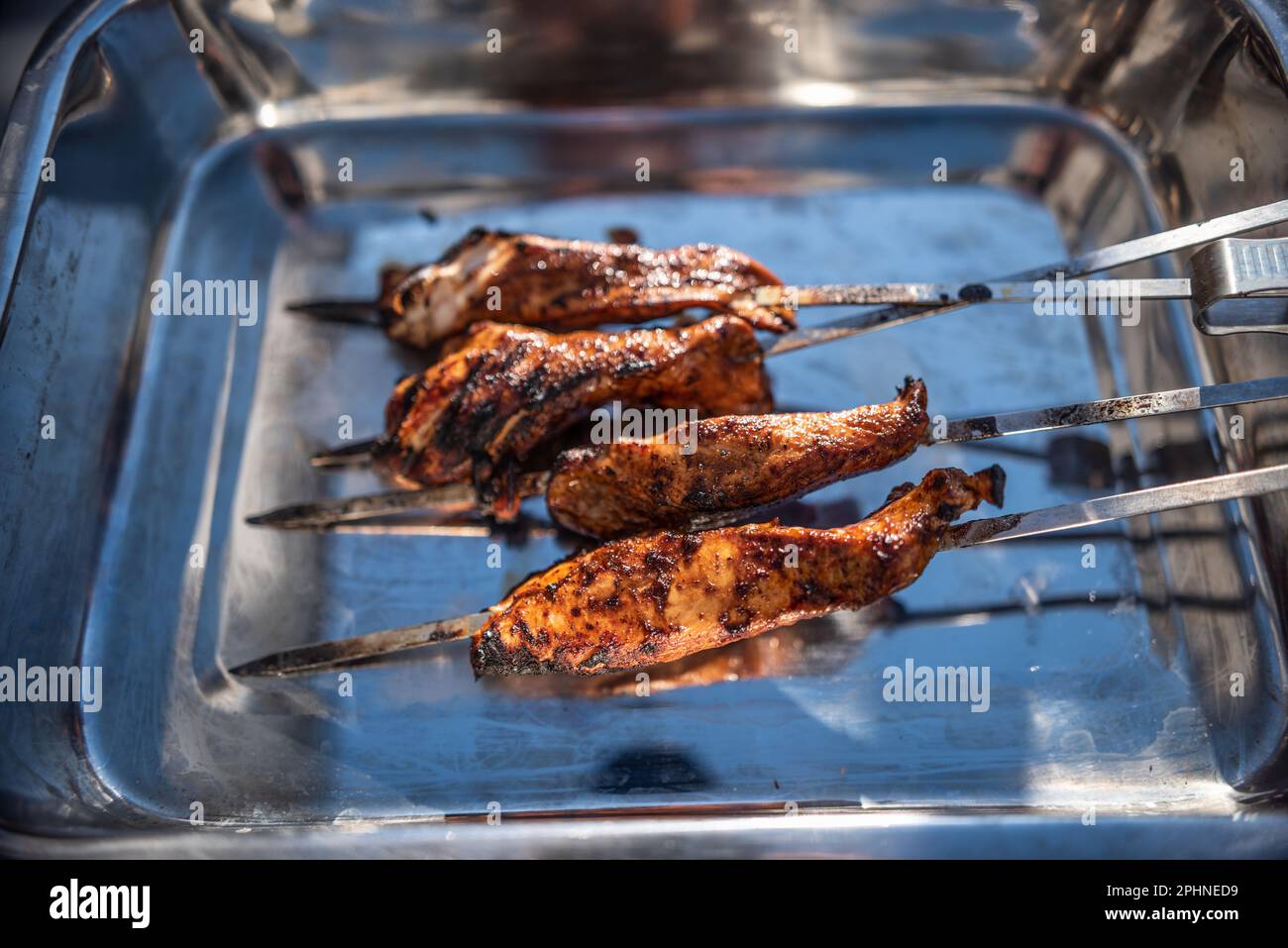 Grigliare gli spiedini con pollo marinato in un recipiente di metallo. Foto Stock