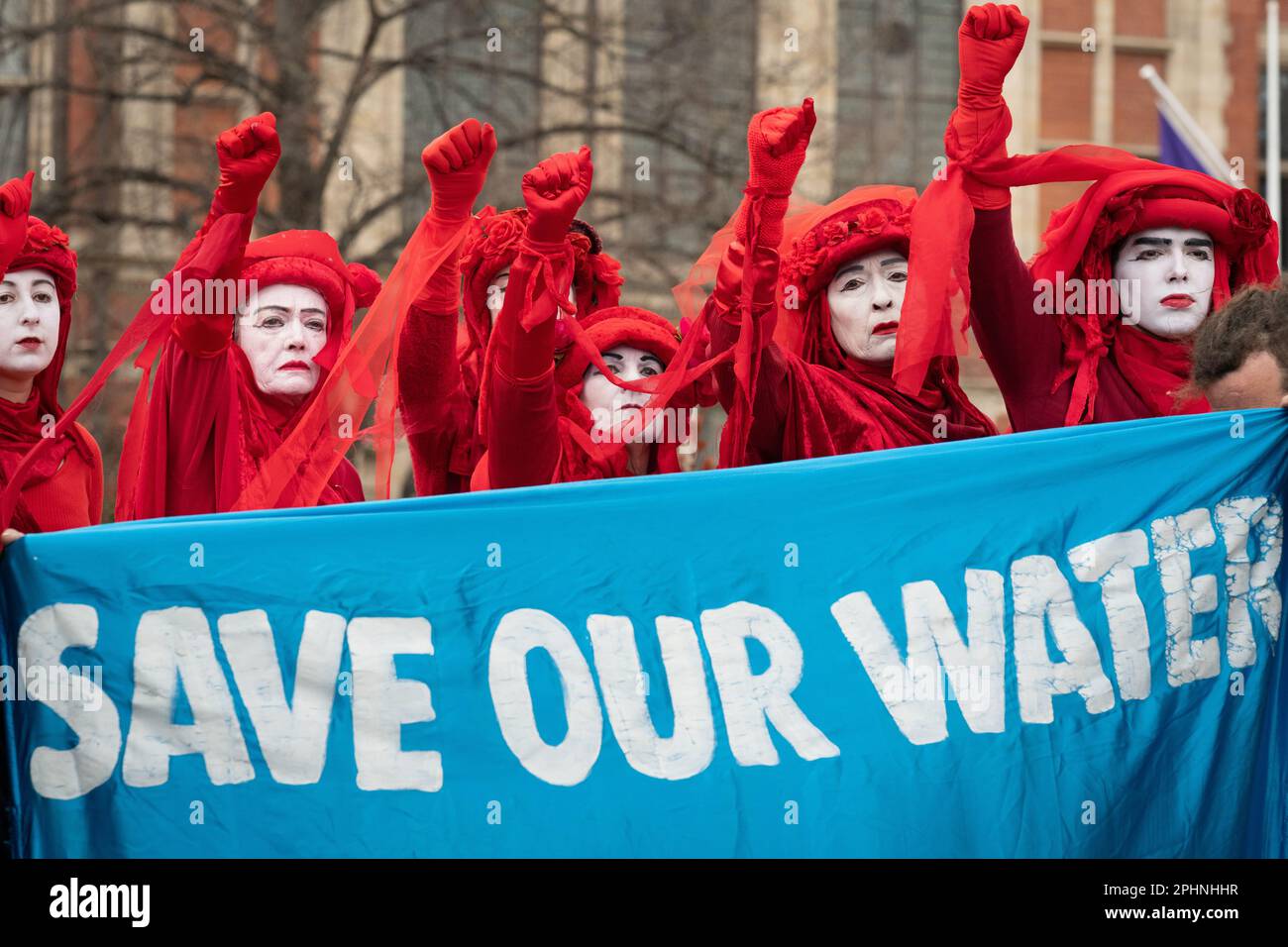 Parliament Square, Londra, Regno Unito. 13 marzo 2023. La troupe mimo dei ribelli rossi con il banner "Salva l'acqua" durante una protesta contro l'inquinamento idrico. Foto Stock