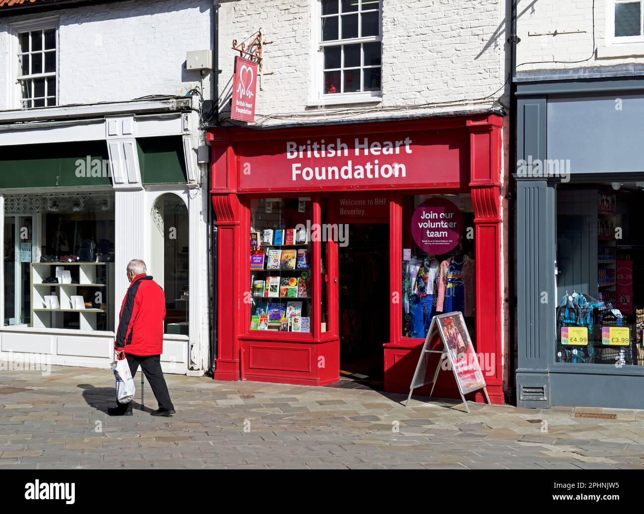 Uomo che passa davanti al negozio di beneficenza della British Heart Foundation a Beverley, East Yorkshire, Inghilterra, Regno Unito Foto Stock