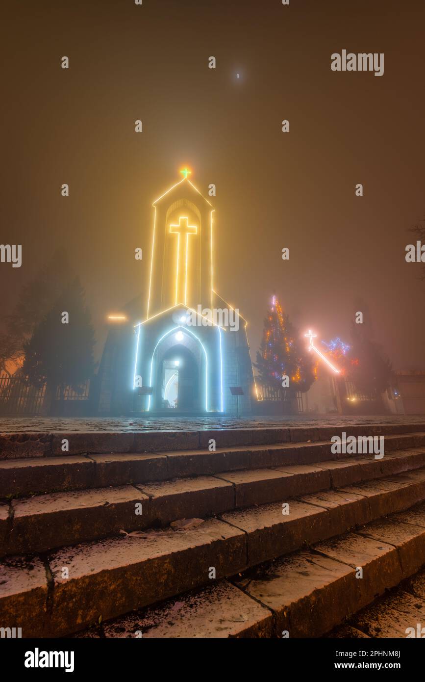 Antica chiesa in pietra di Sapa con cielo notturno nebbia. Destinazione di viaggio più popolare in Sapa, Laocai of Vietnam Foto Stock