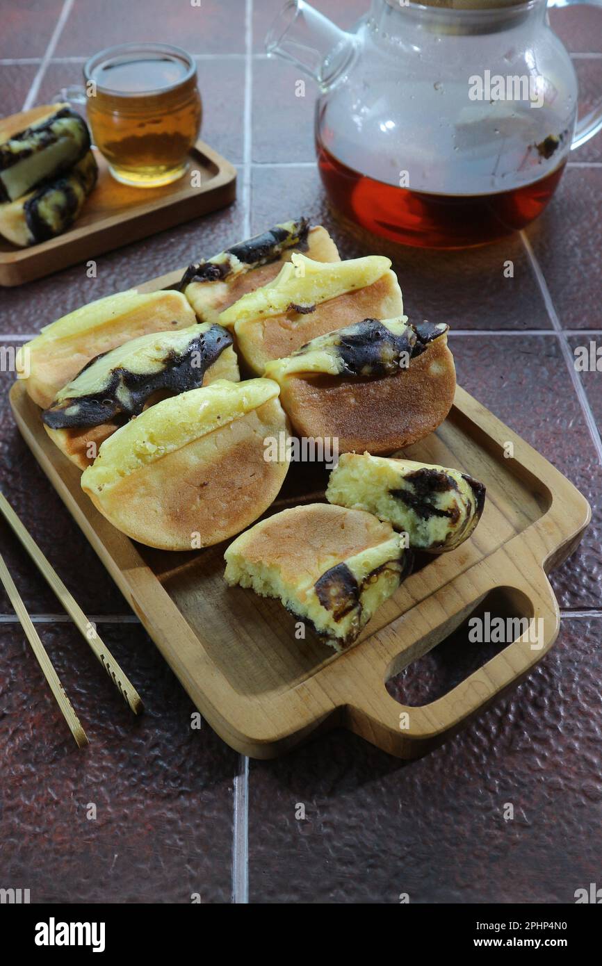 Pukis è uno spuntino tradizionale indonesiano fatto di una pastella a base di farina di grano e cucinato in una speciale casseruola Foto Stock