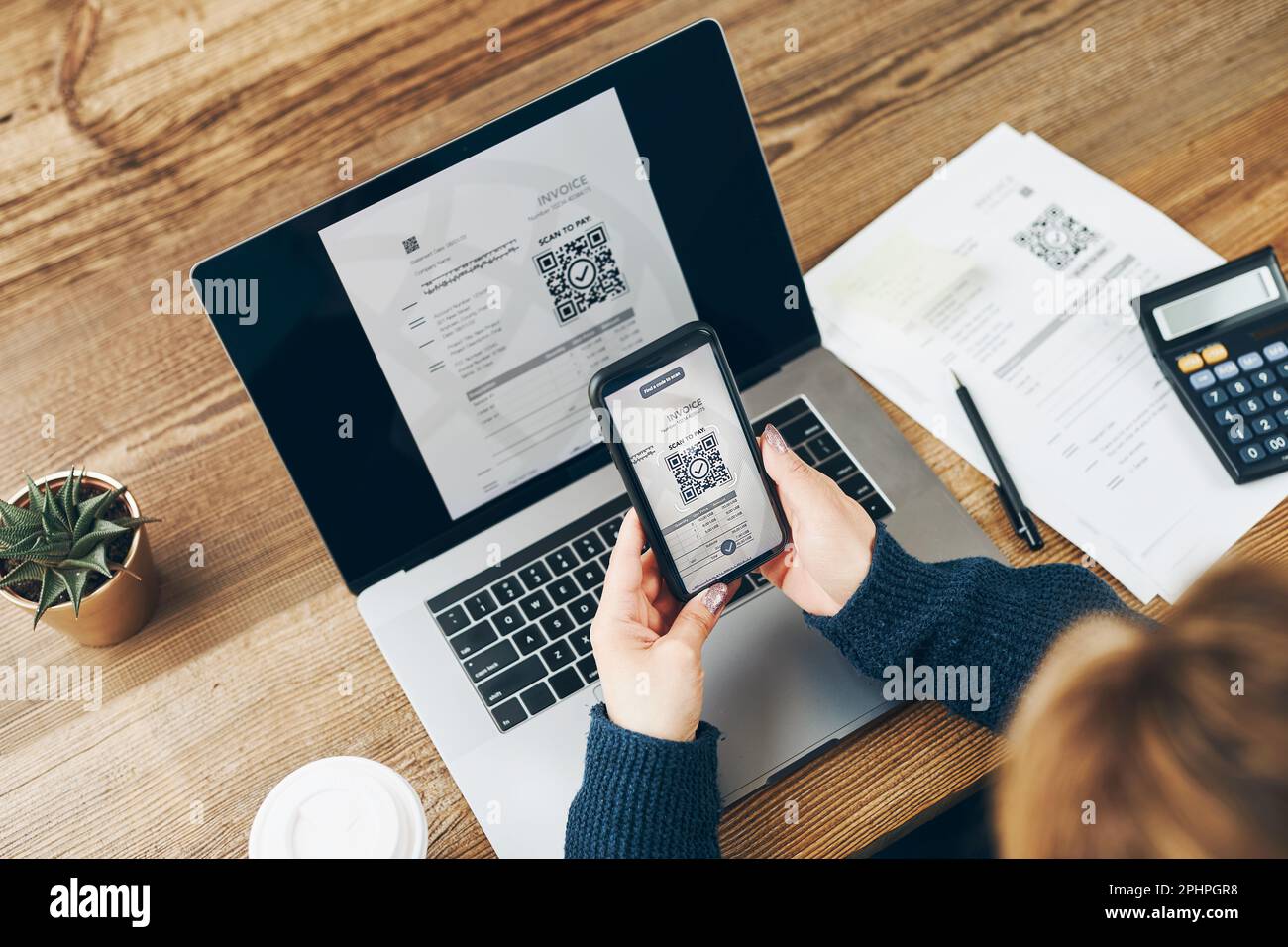 Donna che esegue la scansione del codice QR dalla fattura per effettuare il pagamento utilizzando un sistema di pagamento rapido e sicuro e un lettore di codici smartphone. Donna d'affari che paga le fatture usando exp Foto Stock