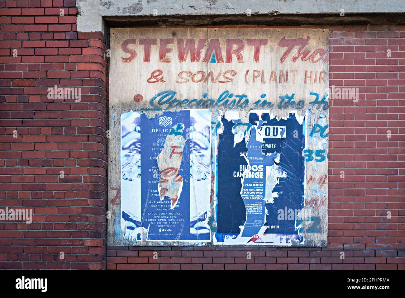 Fly-Posters sul muro di mattoni del magazzino Foto Stock