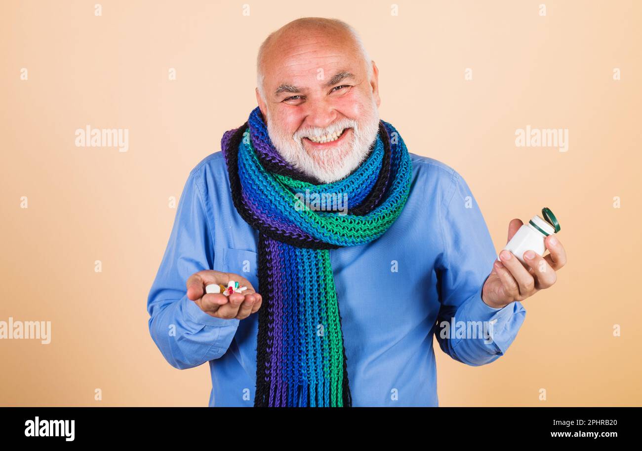 Uomo maturo sorridente con pillole. Medicina, trattamento e assistenza sanitaria. Integratori, vitamine e minerali. Antidolorifici. Concetto medico. Paziente di sesso maschile con Foto Stock