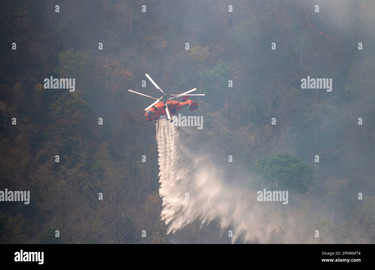 Un elicottero antincendio KA-32 del Dipartimento tailandese di prevenzione e mitigazione delle catastrofi (DDPM) fa cadere l'acqua per spegnere l'incendio della foresta presso la National Reserved Forest Group9. Foto Stock