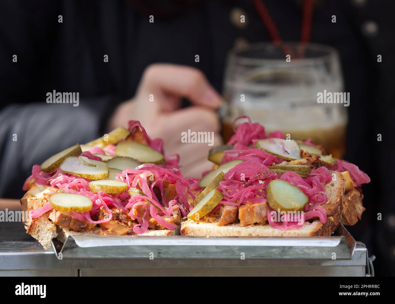 Rinfreschi presso la bancarella del mercato alimentare di strada degli agricoltori, pane con carne tirata, cavolo rosso e sottaceti Foto Stock