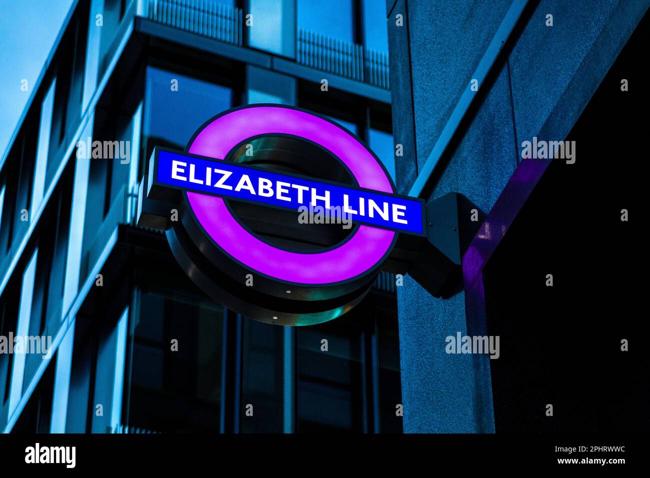 Segno viola per la linea Elizabeth illuminata di notte, Tottenham Court Road, Londra, Regno Unito Foto Stock