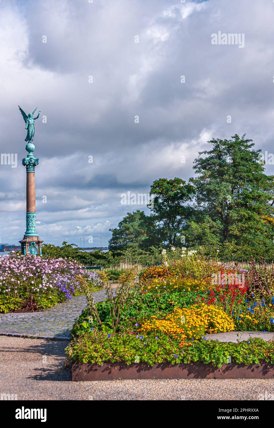 Copenaghen, Danimarca - 13 settembre 2010: Colonna dell'Ammiraglio Ivar Huitfeldt fronteggiata da un campo di fiori di molti colori sotto un paesaggio azzurro. Bronzo verde Foto Stock