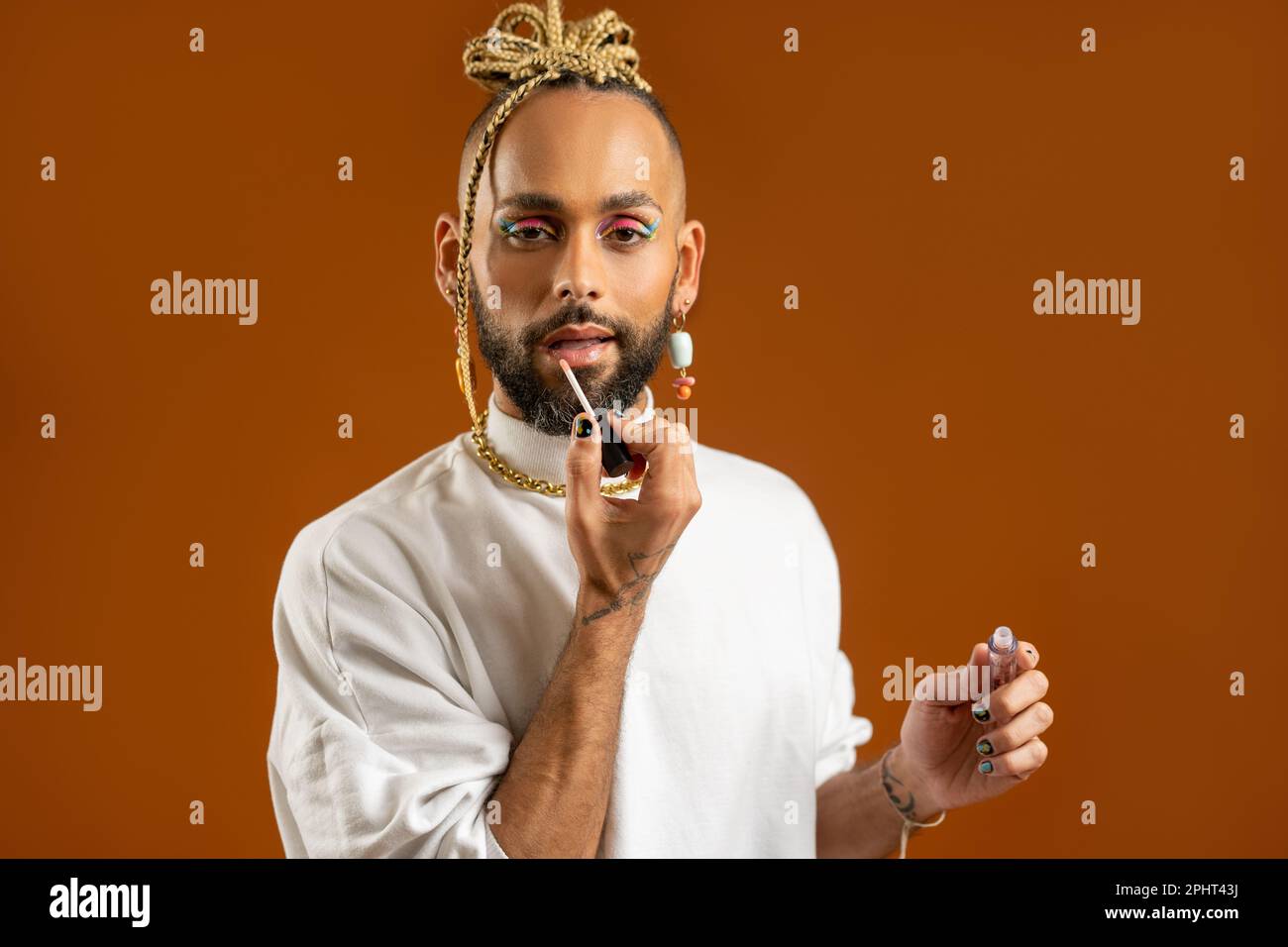 afroamericano gay applicare make up isolato su sfondo arancione vernice  labbra con rossetto isolato sfondo marrone. Concetto lgbtq moda Foto stock  - Alamy