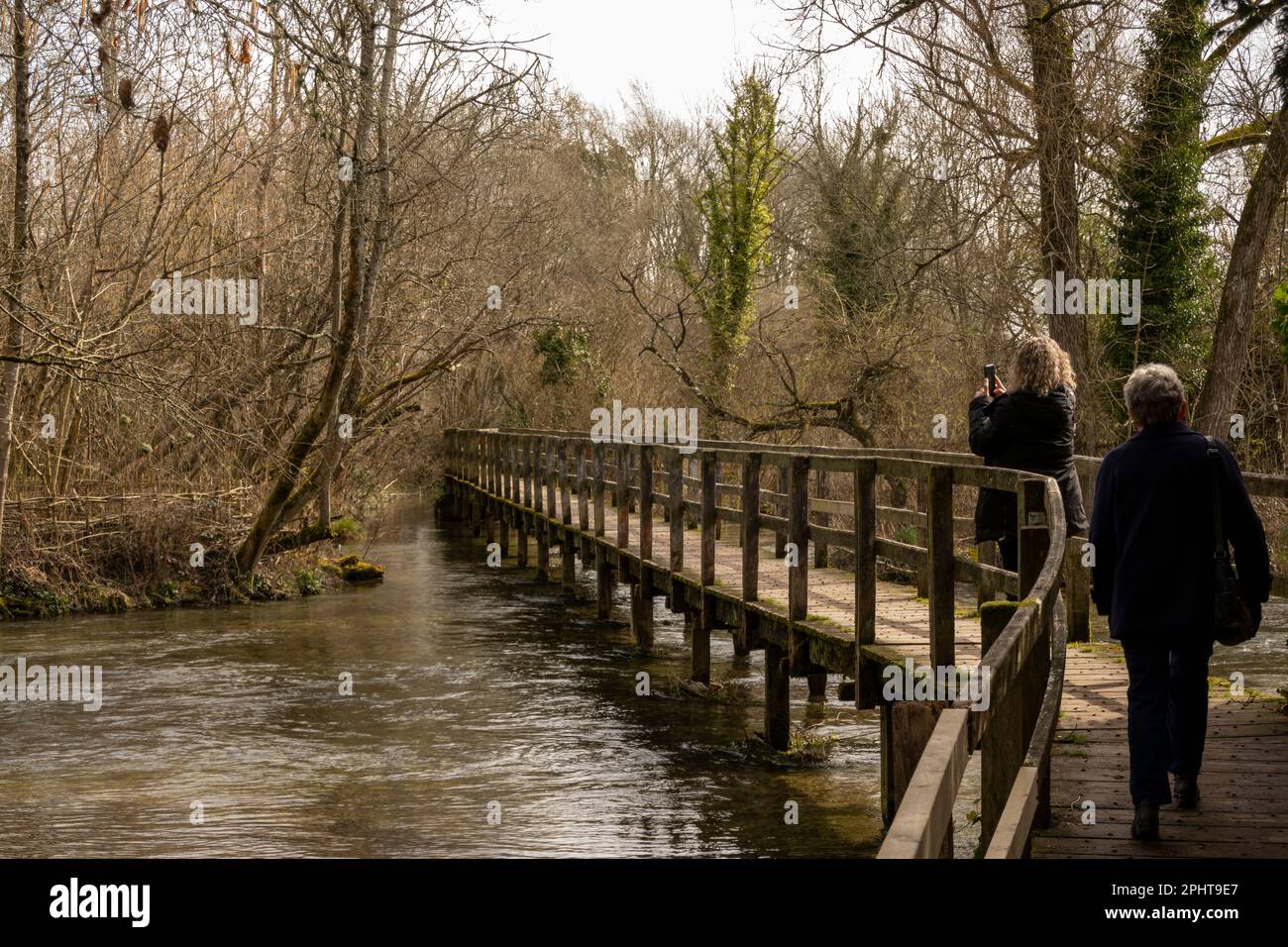 Wherwell, Hampshire, Inghilterra, Regno Unito. 2023. Due donne fanno una passeggiata invernale attraverso il famoso River Test a Wherwell. Famoso per la pesca alla trota. Foto Stock