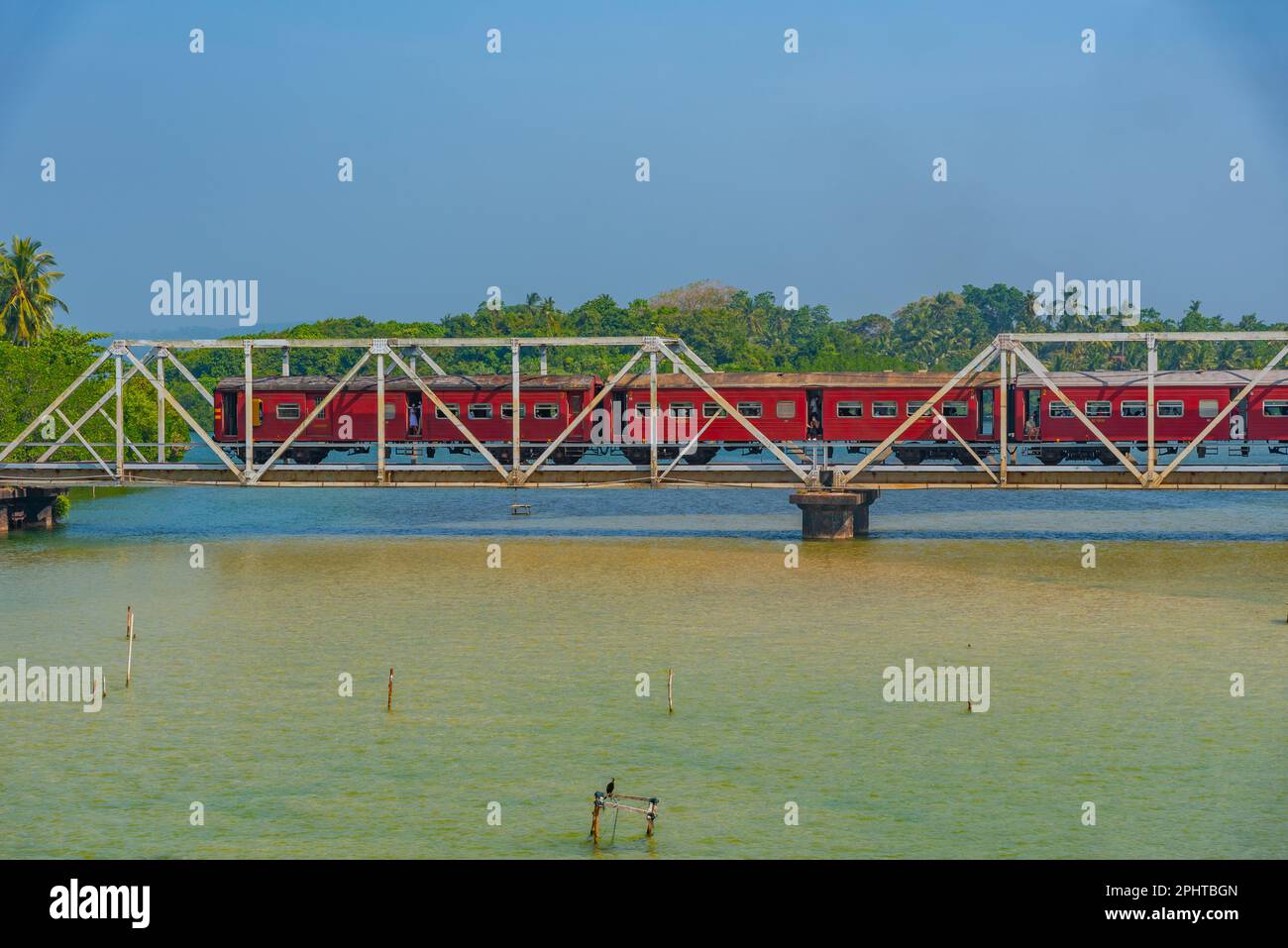 Treno che attraversa la laguna di Koggala su un ponte, Sri Lanka. Foto Stock