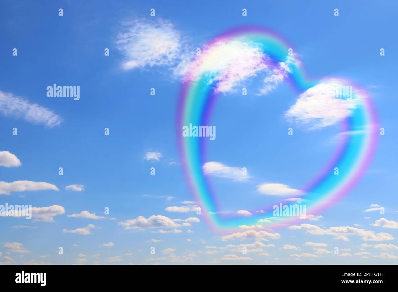 Splendida vista dell'arcobaleno a forma di cuore e delle nuvole bianche nel cielo blu nelle giornate di sole Foto Stock