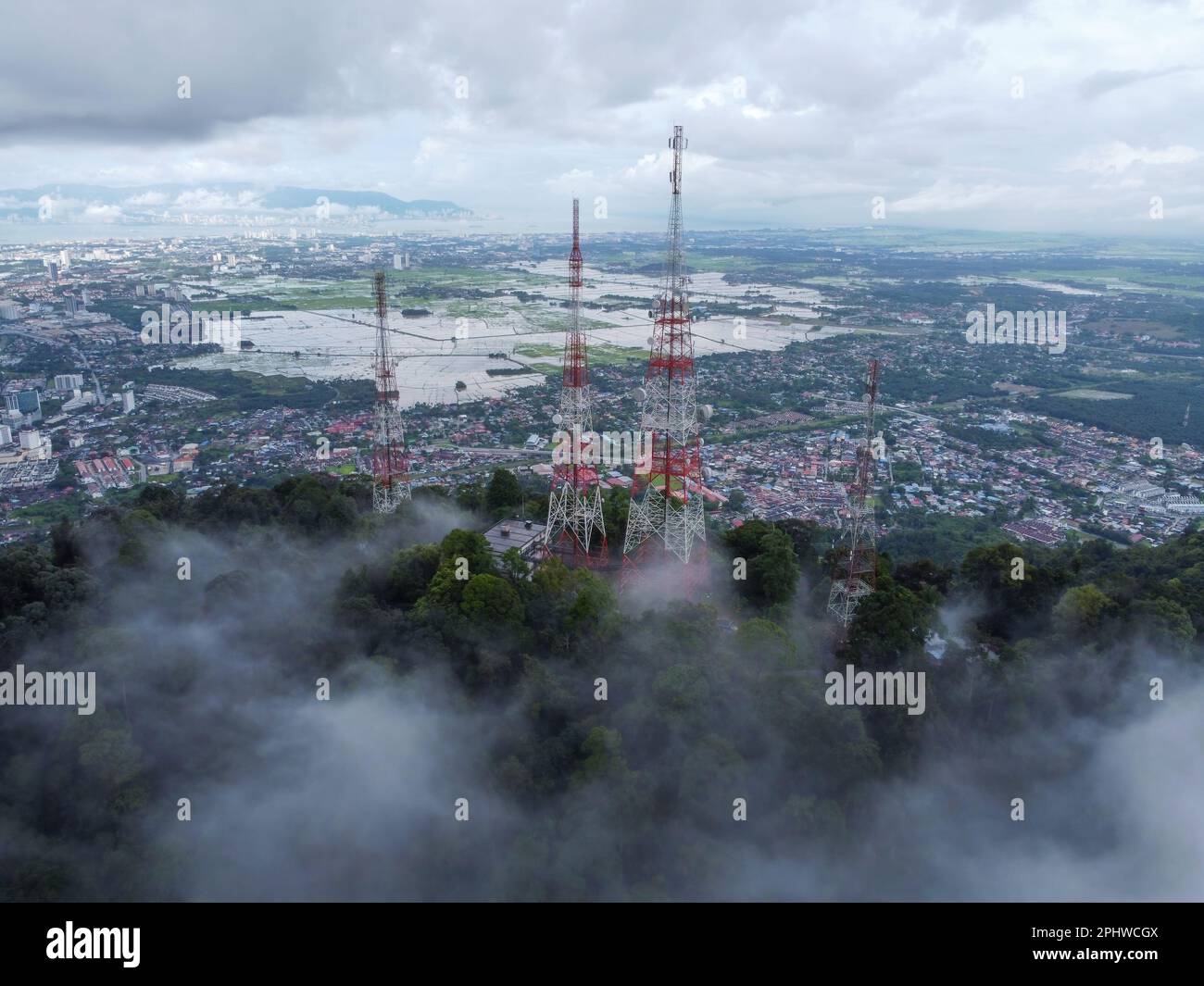 Vista aerea torre di telecomunicazioni in cima alla collina con sfondo di casa residenziale Foto Stock