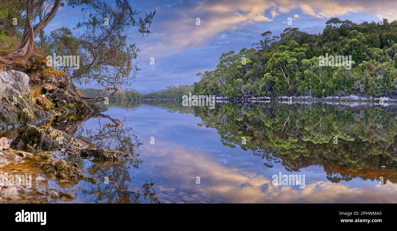 La luce del mattino presto e le nuvole riflesse sull'acqua di Melaleuca Inlet, il parco nazionale del sud-ovest, Tasmania, Australia Foto Stock