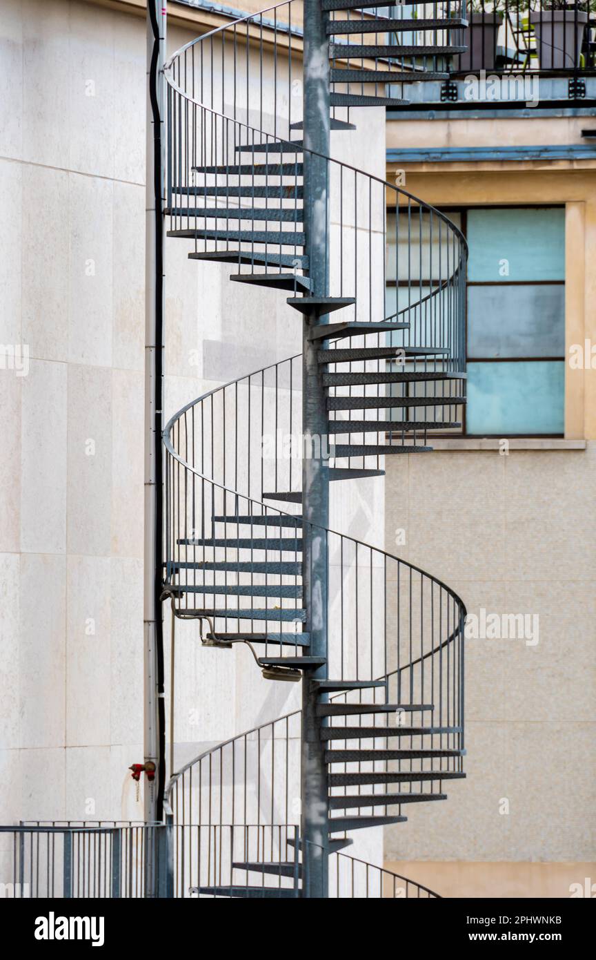 Scala esterna di fuga a spirale metallica che conduce alle uscite di emergenza sul retro di un edificio Foto Stock