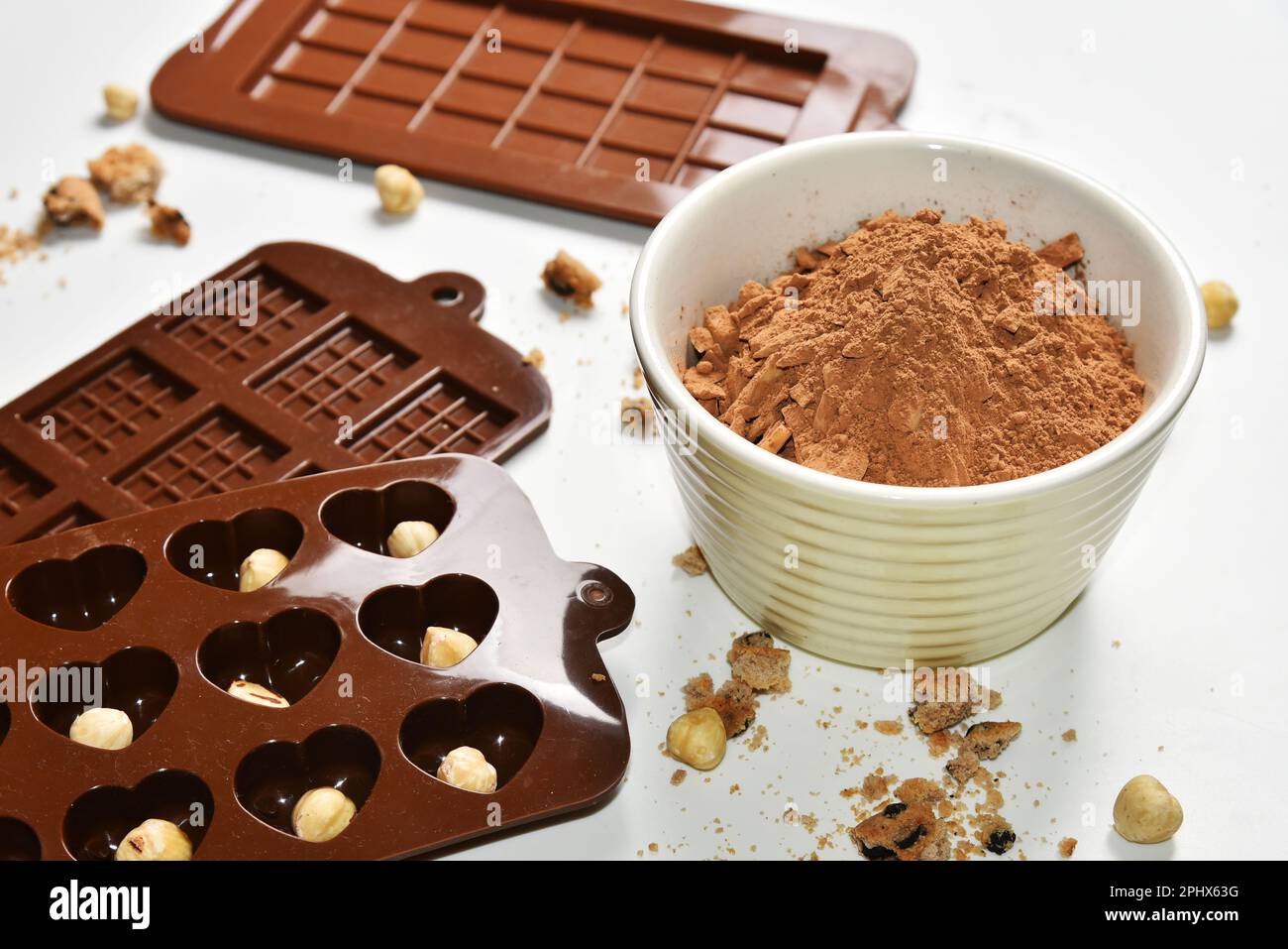 Polvere di cacao, noci e biscotti sbriciolati, stampi in silicone per la preparazione del cioccolato, biscotti fatti in casa per la dolcezza degli alimenti Foto Stock