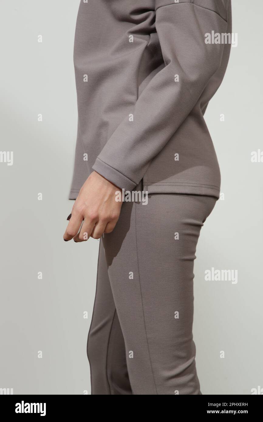 Serie di foto di studio di giovane modello femminile che indossa tutto grigio pietra confortevole vestito di base, dolcevita viscosa e pantaloni svasati base. Foto Stock