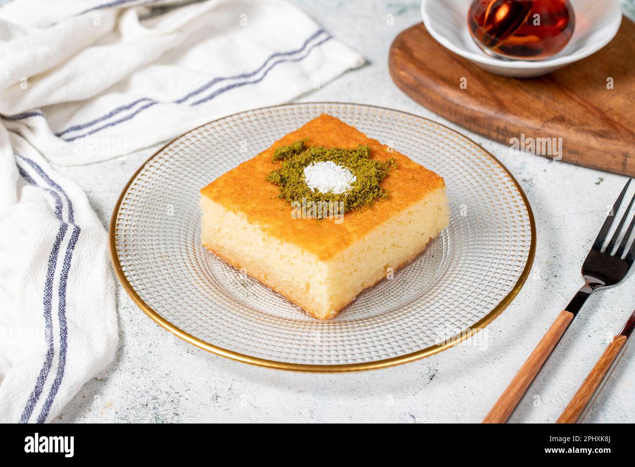 Dessert Revani. Dolce di semola al pistacchio. Ramadan dolci. Prelibatezze tradizionali della cucina turca. Dessert Revani con sciroppo sul dorso grigio Foto Stock