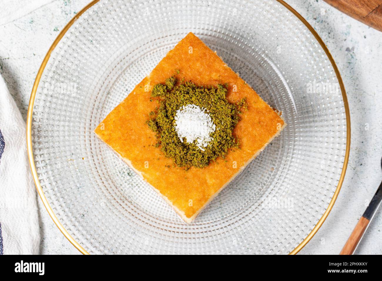 Dessert Revani. Dolce di semola al pistacchio. Ramadan dolci. Prelibatezze tradizionali della cucina turca. Dessert Revani con sciroppo sul dorso grigio Foto Stock